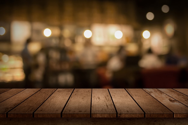 Holztischplatte auf Bokeh Coffee Shop oder Café Restaurant Hintergrund.