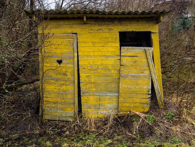 Holztoilette im Garten mit herzförmigem Loch an der Tür