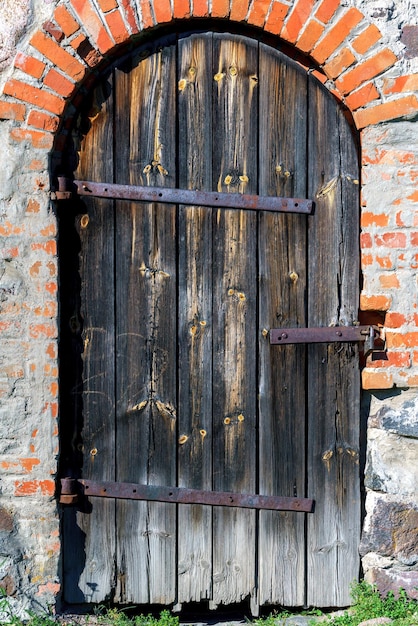Holztür in einer Wand aus unebenen Steinen Vintage-Gebäude-Hintergrund