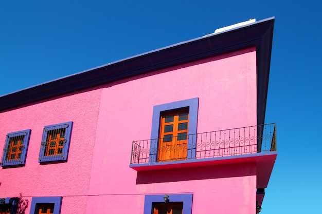 Holztüren der mexikanischen rosa Hausfassade