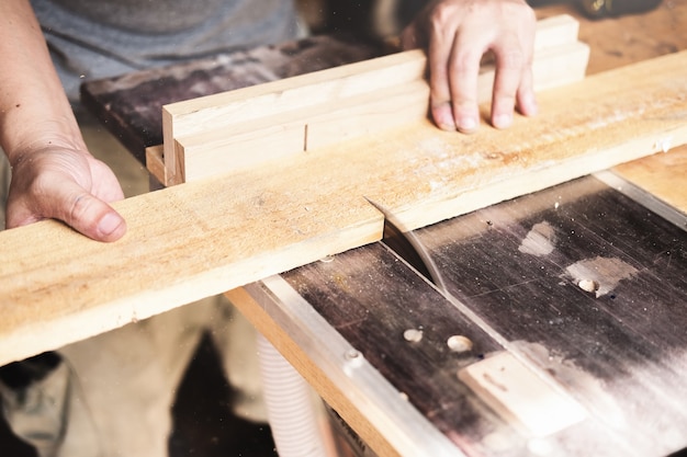 Holzverarbeiter verwenden Bretterschneidemaschinen, um Holztische für Kunden zu montieren und zu bauen.