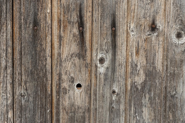 Holzwand aus alten Brettern mit Knoten und rostigen Nägeln, Wandpaneel, vertikales Holz mit natürlichem Hintergrund