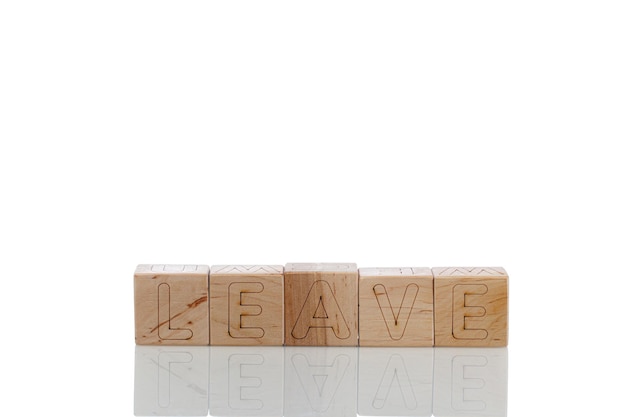 Holzwürfel mit Buchstaben verlassen auf weißem Hintergrund