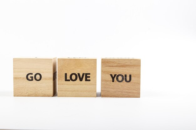 Holzwürfel mit der Aufschrift Go Love You auf weißem Hintergrund