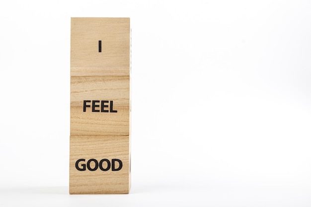 Holzwürfel mit der Aufschrift „I Feel Good“ auf weißem Hintergrund in Großaufnahme