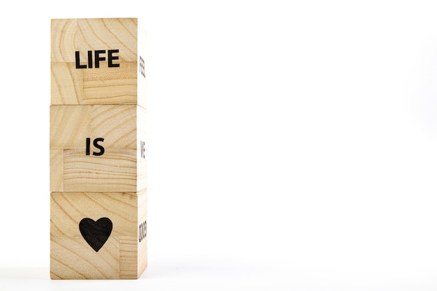 Holzwürfel mit der Aufschrift Life is Love auf weißem Hintergrund