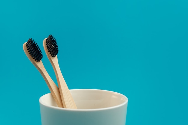 Holzzahnbürste auf blauem Hintergrund in einer Tasse