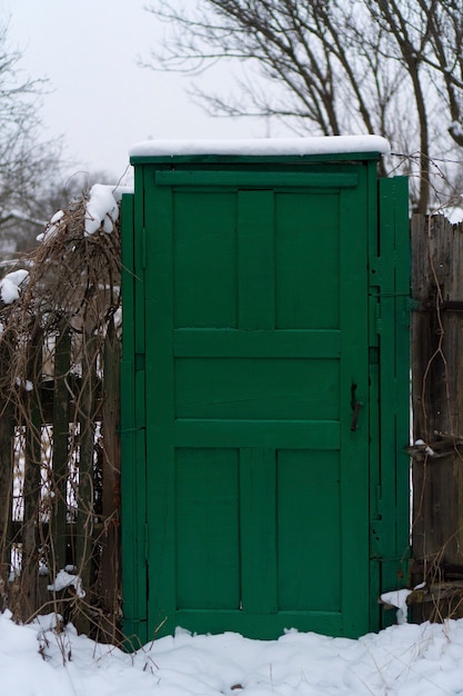 Foto holzzaun mit schöner klassischer grüner hölzerner eingangstür mit griff
