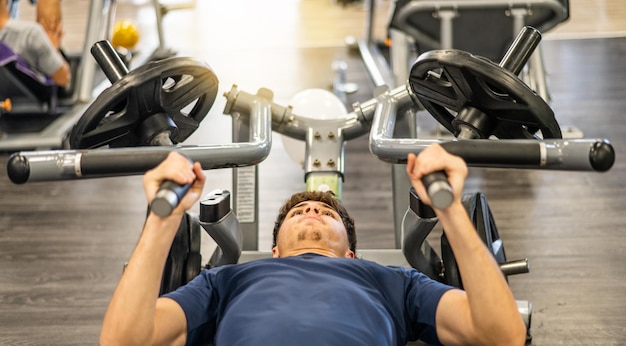 Hombre De 20 Años Haciendo Ejercicio Con Maquinas De Pesas En El Gimnasio Es Fuerte Y Ganando Masa Muscular