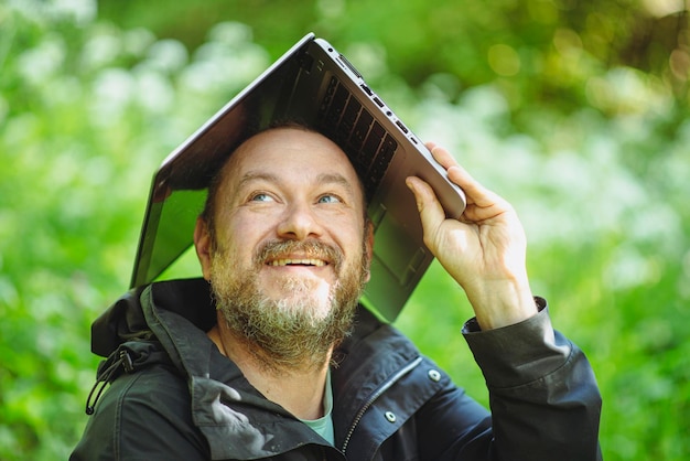 Hombre de 43 años en el bosque con una laptop.