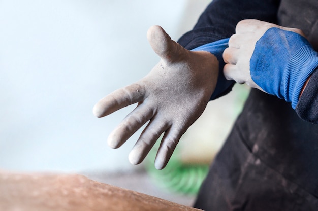 Hombre de 62 años que trabaja en la tienda de fibra, se pone guantes