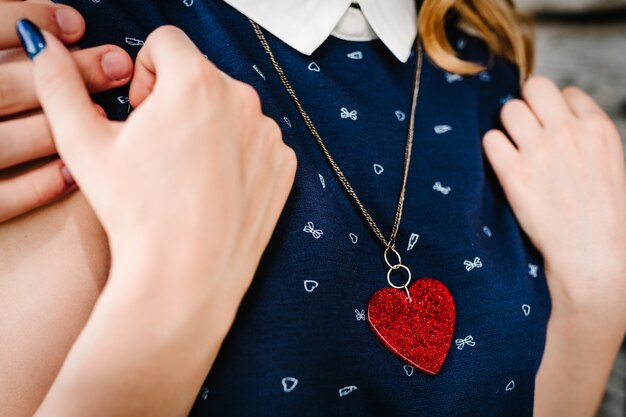 El hombre abraza a una mujer con el corazón colgando alrededor de su cuello