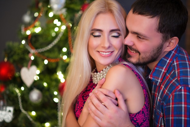 El hombre abraza a su bella joven esposa