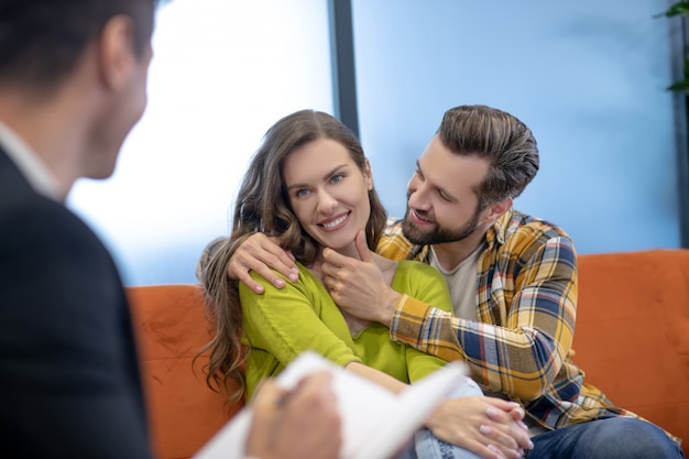 Foto hombre abrazando a su esposa durante la sesión de psicoterapia