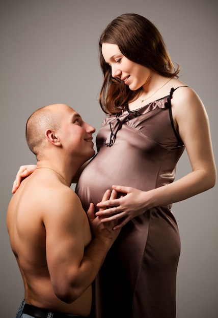 Hombre abrazando el vientre de mujer embarazada