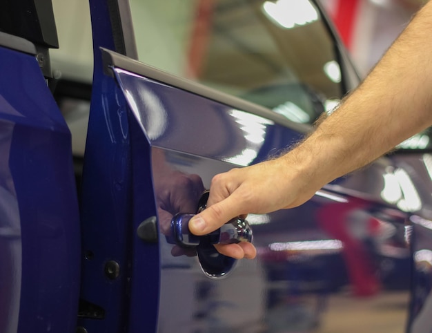 Un hombre abre un primer plano del coche La manija de la puerta