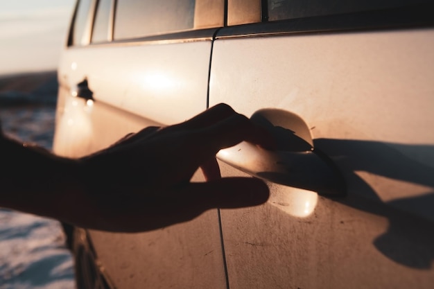 El hombre abre la puerta del auto en invierno