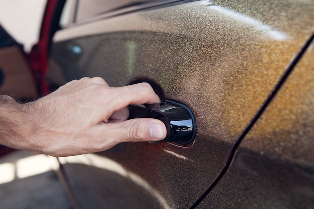 Un hombre abre la puerta de un auto