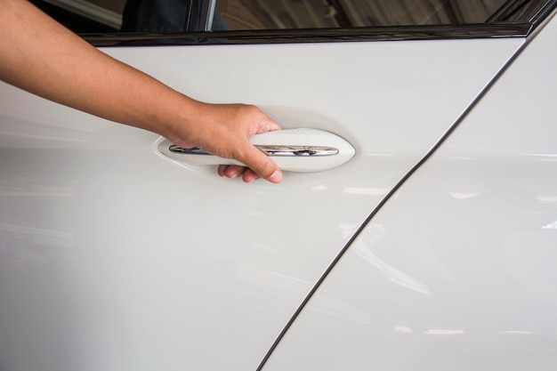 Un hombre abriendo la puerta del coche. Mano en la manija.