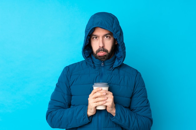 Hombre con abrigo de invierno sobre pared aislada