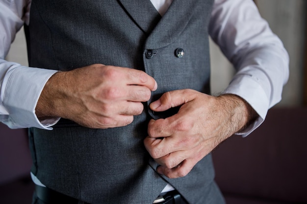 Foto el hombre abrocha un botón en una chaqueta