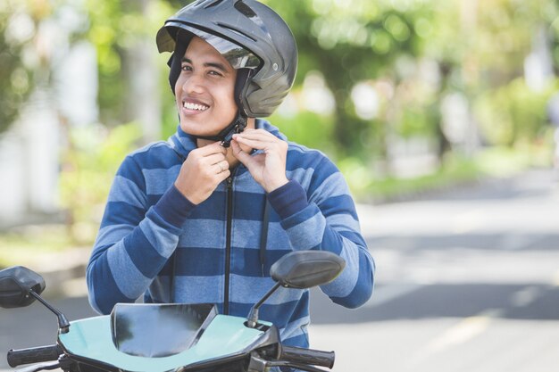 Hombre abrochándose el casco de moto