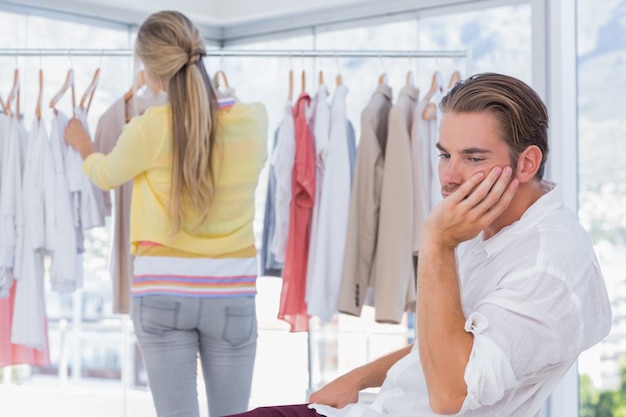 Hombre aburrido mientras su novia está de compras