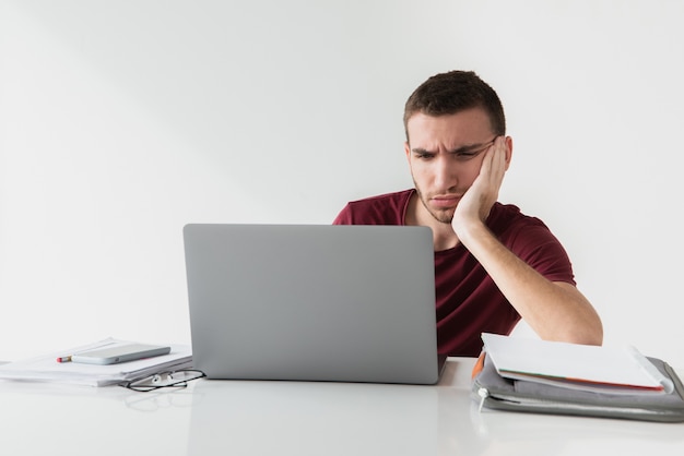 Foto hombre aburrido en su espacio de trabajo