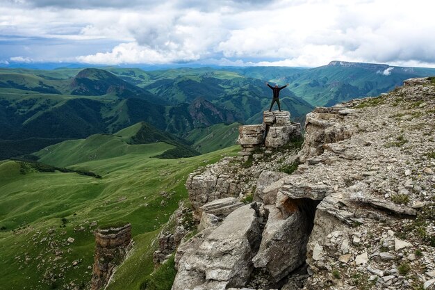 Un hombre en el acantilado de la meseta contra el fondo del monte Elbrus Bermamyt