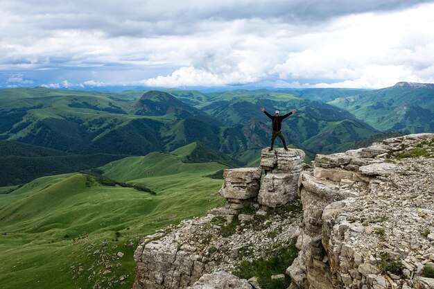 Un hombre en el acantilado de la meseta contra el fondo del monte Elbrus Bermamyt