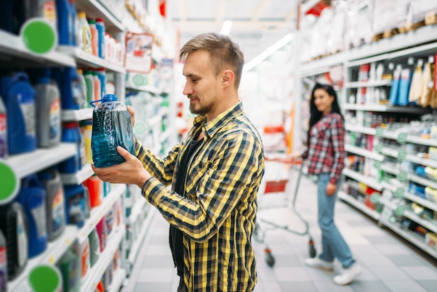 Hombre con aceite de motor, pareja en supermercado