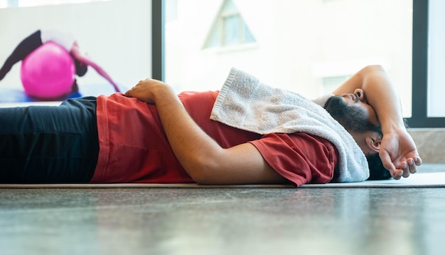 Hombre acostado en el piso mientras descansa en el piso del GIMNASIO