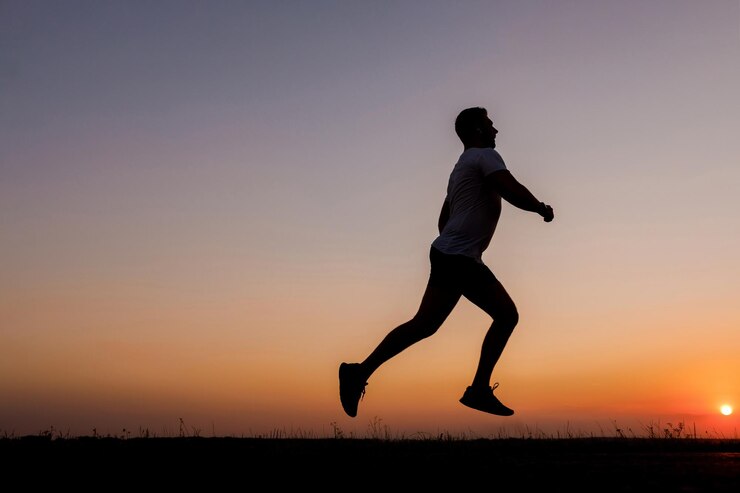 Hombre activo corriendo durante la puesta de sol