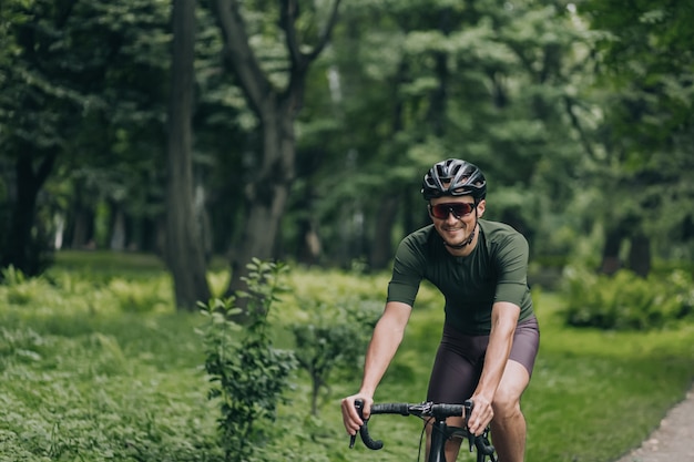 Hombre activo feliz con bicicleta para entrenamiento intensivo en el parque