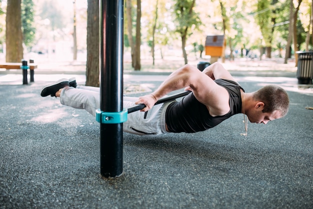 Hombre activo guapo sano con cuerpo musculoso en forma haciendo ejercicios de entrenamiento