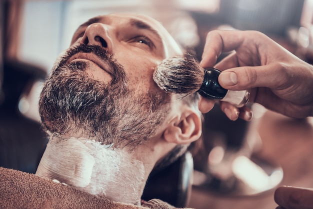 Hombre adulto afeitado en una elegante barbería