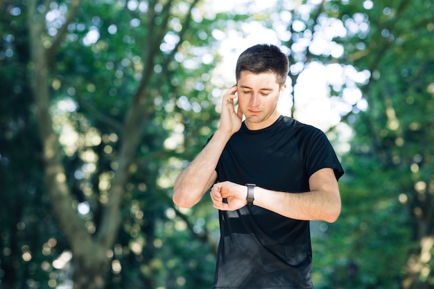 Hombre adulto corriendo al aire libre con auriculares inalámbricos escuchando música