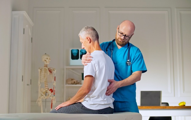 Un hombre adulto entrena la fuerza muscular con un médico profesional en una moderna clínica de rehabilitación.