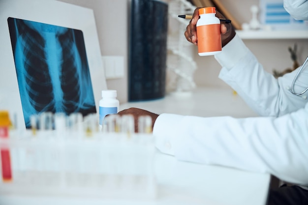 El hombre adulto está demostrando una botella de medicina