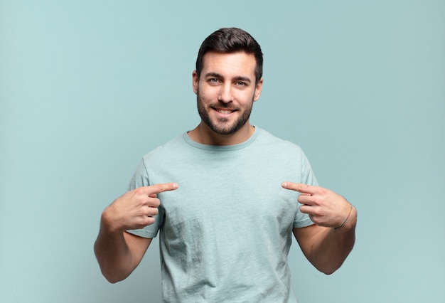 Hombre adulto guapo joven que parece orgulloso, positivo y casual apuntando al pecho con ambas manos