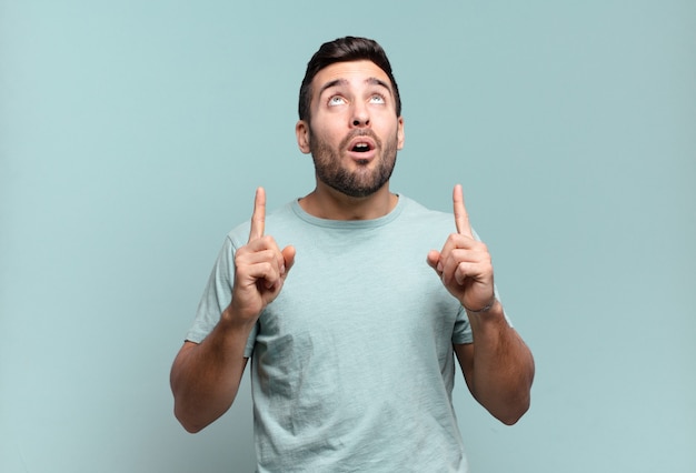 Foto hombre adulto guapo joven que se siente asombrado y con la boca abierta apuntando hacia arriba con una mirada de asombro y sorpresa