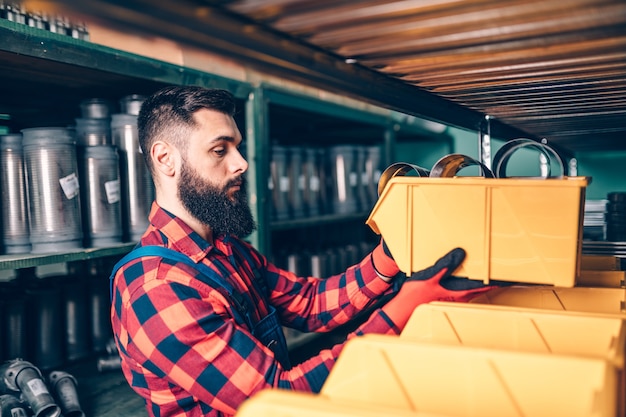 Hombre adulto guapo que trabaja en el almacén de repuestos de automóviles y camiones.