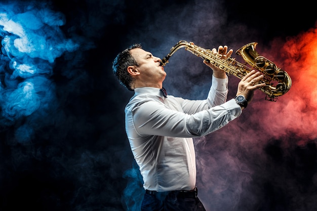 Hombre adulto guapo tocando el saxofón