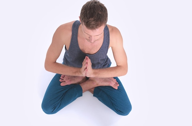 Foto hombre adulto haciendo ejercicio de yoga sobre fondo blanco.