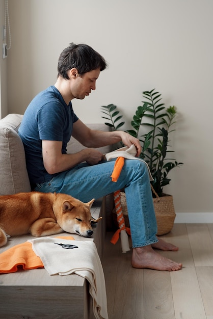 Foto hombre adulto haciendo juguetes educativos caseros para perros usando un tutorial de internet