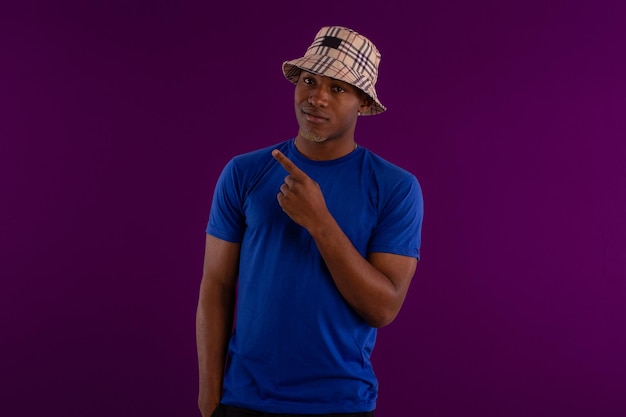 Hombre adulto joven de piel negra con sombrero y camisa en foto de estudio