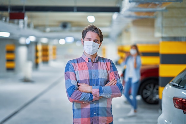 Hombre adulto en máscara de protección en estacionamiento subterráneo
