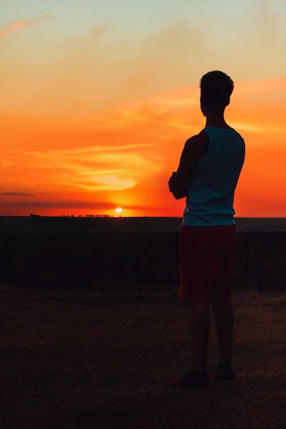 Hombre adulto mirando la puesta del sol