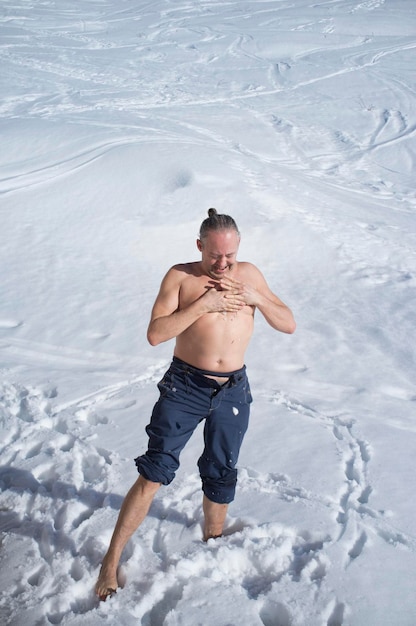 Hombre adulto practicando crioterapia en la nieve