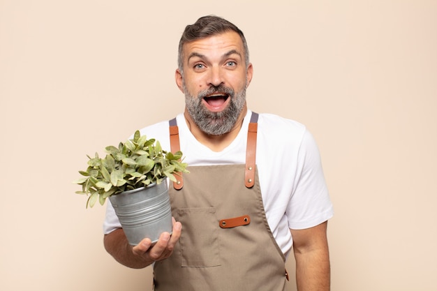 Hombre adulto que parece feliz y gratamente sorprendido, emocionado con una expresión fascinada y conmocionada